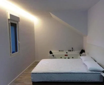 Dormitorio con jacuzzi privado junto a la cama del apartamento superior.