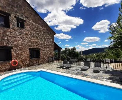 Edificio de piedra con piscina exterior y vistas a la naturaleza de este hotel boutique.