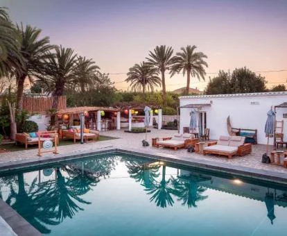 Fabulosa zona exterior con piscina y mobiliario rodeada de vegetación de este hotel boutique.