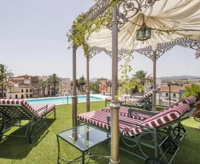Agradable zona exterior con piscina, solarium y vistas a la ciudad de este hotel boutique.