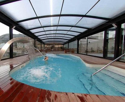 Mujer disfrutando de la piscina de hidroterapia con vistas al exterior del spa.