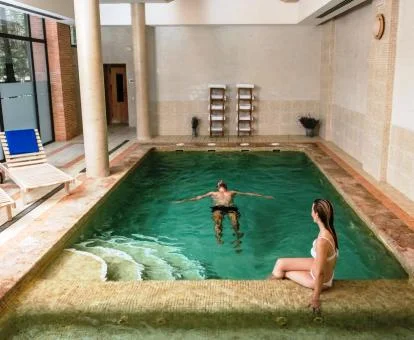 Pareja disfrutando de la zona de aguas del centro de bienestar del hotel.