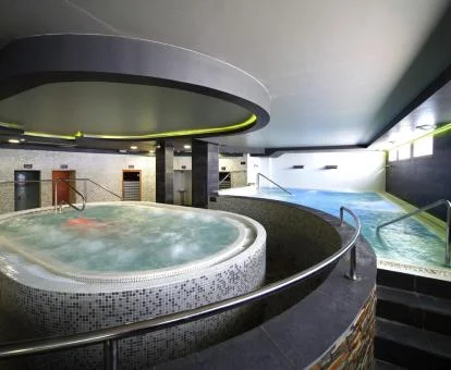 Zona de aguas con piscina cubierta y jacuzzi del spa.