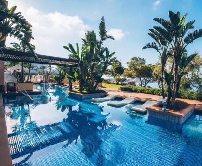 Espectacular piscina con bellos jardines y vistas al mar.