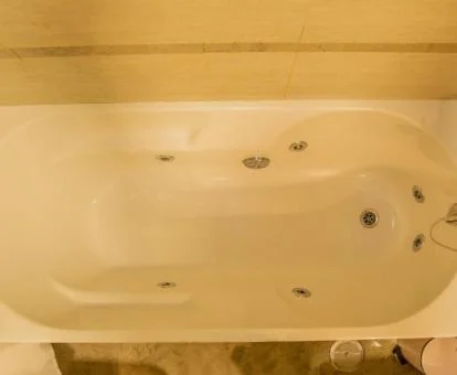 Bañera de hidromasaje privada en el baño de este acogedor apartamento.