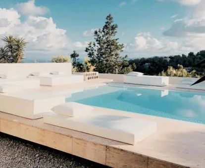 Preciosa piscina exterior de este hotel solo para adultos con cómodas camas y rodeada de naturaleza.
