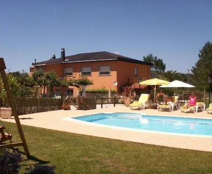 Edificio de este alojamiento rural con amplios jardines y piscina al aire libre.