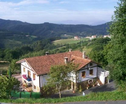 Edificio de este hotel rural con vistas al campo verde que lo rodea.