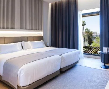Elegante habitación con balcón y vistas a los jardines del este coqueto hotel.