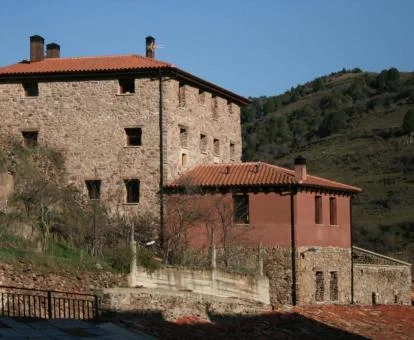 Edificio de piedra de este acohedor hotel rural con vistas a las montañas.