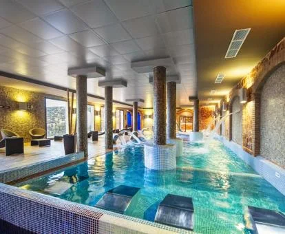 Fabulosa piscina con elementos de hidroterapia y vistas al exterior del centro de bienestar del hotel.