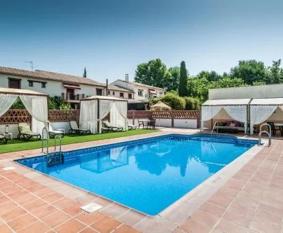 Hotel rural con piscina y mobiliario exterior.