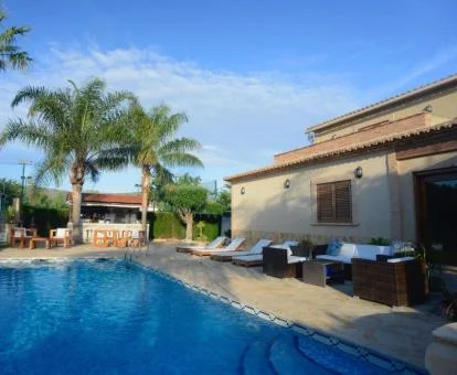 Coqueto hotel con encanto con piscina rodeada de vegetación.