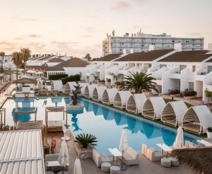 Piscina exterior con amplio solarium y rodeada de los alojamientos de este maravilloso hotel.