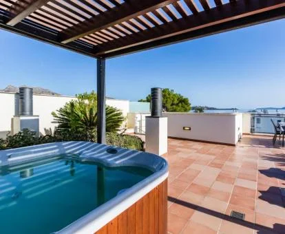 Amplia terraza con un gran jacuzzi privado al aire libre de este coqueto ático.
