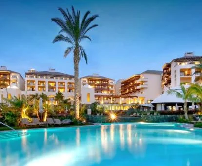 Hotel con encanto con gran piscina rodeada de vegetación.