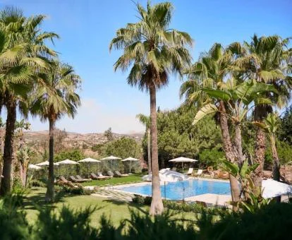 Maravillosa zona exterior rodeada de vegetación con piscina y solarium del hotel.