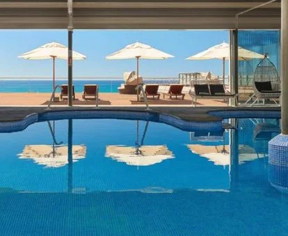 Amplia piscina cubierta del spa del hotel con vistas al mar.