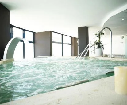 Piscina cubierta con elementos de hidroterapia del spa del hotel.