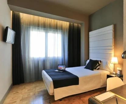 Una de las elegantes habitaciones dobles de este hotel con tonos crema y escritorio.