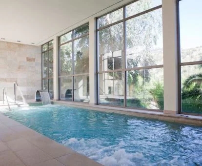 Piscina de hidroterapia con vistas al exterior del spa.