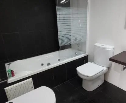 Baño con bañera de hidromasaje privada de este moderno apartamento.