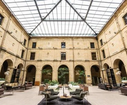 Precioso patio central con techo de cristal y mobiliario de este hotel boutique.