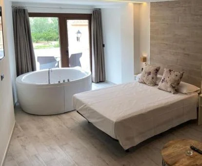 Dormitorio con un amplio jacuzzi privado junto a la cama de este estudio.