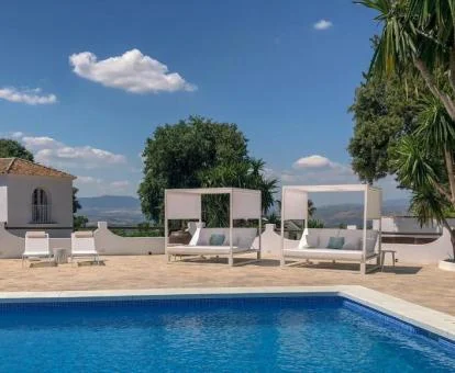 Piscina con tumbonas y vistas a los alrededores de este acogedor hotel.