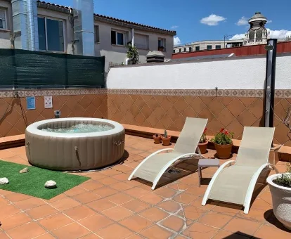 Agradable terraza con tumbonas y jacuzzi privado del apartamento ático.