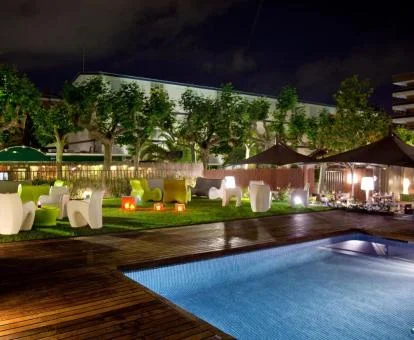 Jardín con zonas de estar en el exterior y piscina del hotel.