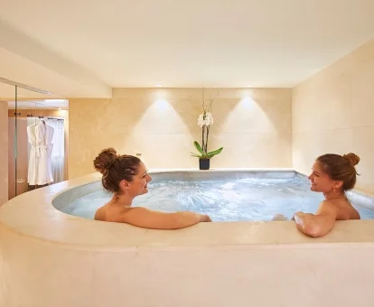 Pareja disfrutando de la zona de aguas del centro de spa del hotel.