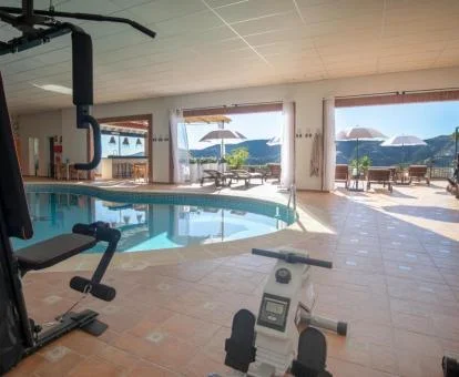Zona de bienestar de este hotel solo para adultos con piscina cubierta, gimnasio y vistas a la naturaleza.