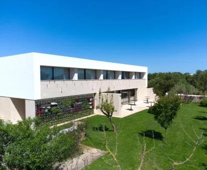 Moderna fachada de este hotel solo para adultos rodeado de jardines.