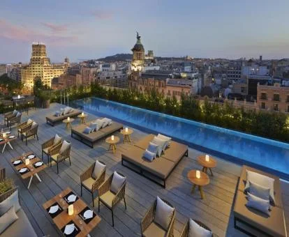 Terraza con piscina de borde infinito y vistas a la ciudad del hotel.