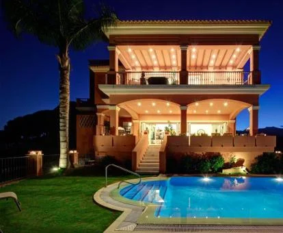 Hermosa villa con iluminación nocturna y piscina que alberga este fabuloso hotel boutique.