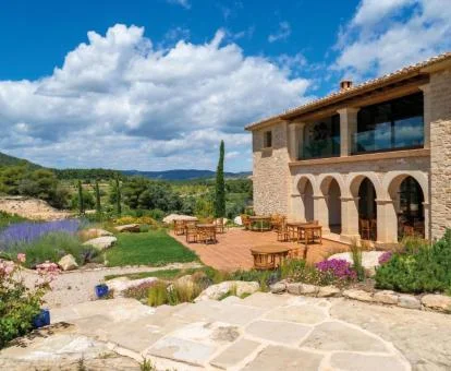 Edificio de piedra de este hermoso hotel boutique con zona exterior rodeada de vegetación.