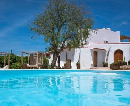 Coqueto hotel rural con piscina exterior y camas balinesas rodeado de naturaleza.