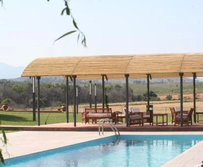 Piscina exterior con terraza cubierta y vistas a la campiña de este hotel rural.