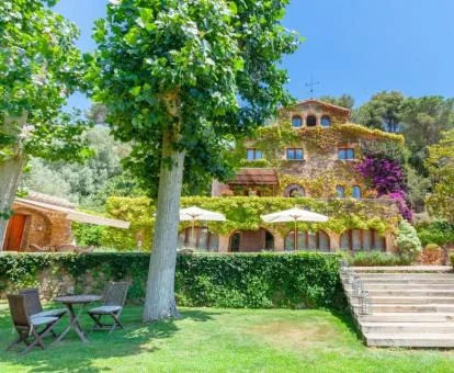Fachada con vegetación colorida de este precioso hotel con amplios jardines y zonas de estar exteriores.
