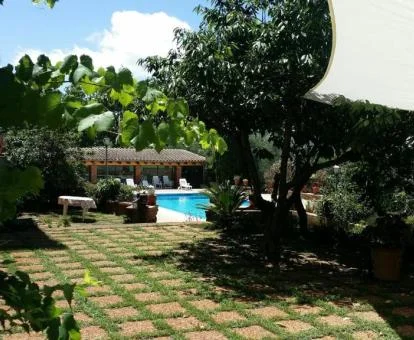 Zona exterior ajardinada con piscina de este hermoso hotel rural.
