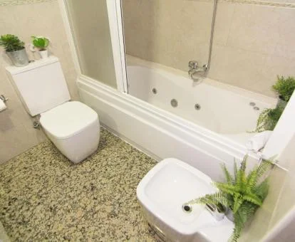 Baño con bañera de hidromasaje privada de este moderno apartamento.