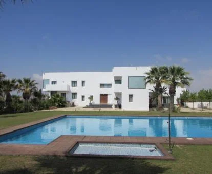 Hotel con encanto rodeado de jardines con piscina exterior.