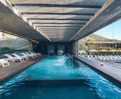 Piscina cubierta con hidroterapia y vistas al exterior del centro de bienestar del hotel.
