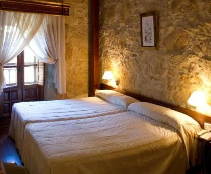 Una de las coquetas habitaciones con paredes de piedra a la vista del hotel.