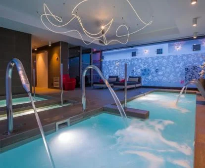 Piscina cubierta con hidroterapia en funcionamiento del spa del hotel.