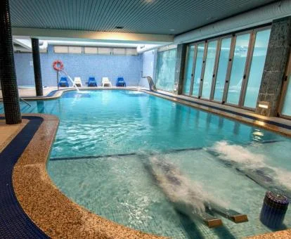 Piscina cubierta con elementos de hidroterapia del spa.