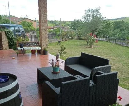 Zona exterior con jardín y terraza amueblada de esta coqueta casa.