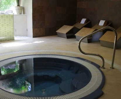 Jacuzzi interior con zona de relajación del spa del hotel.