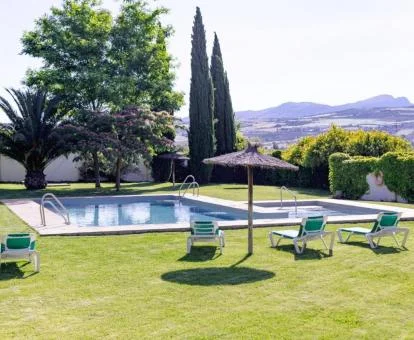 Agradable zona exterior con piscina rodeada de jardines de este hotel boutique.